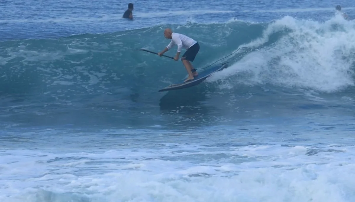 Michael Dolsey riding a Playa Hermosa wave on a stand-up paddleboard